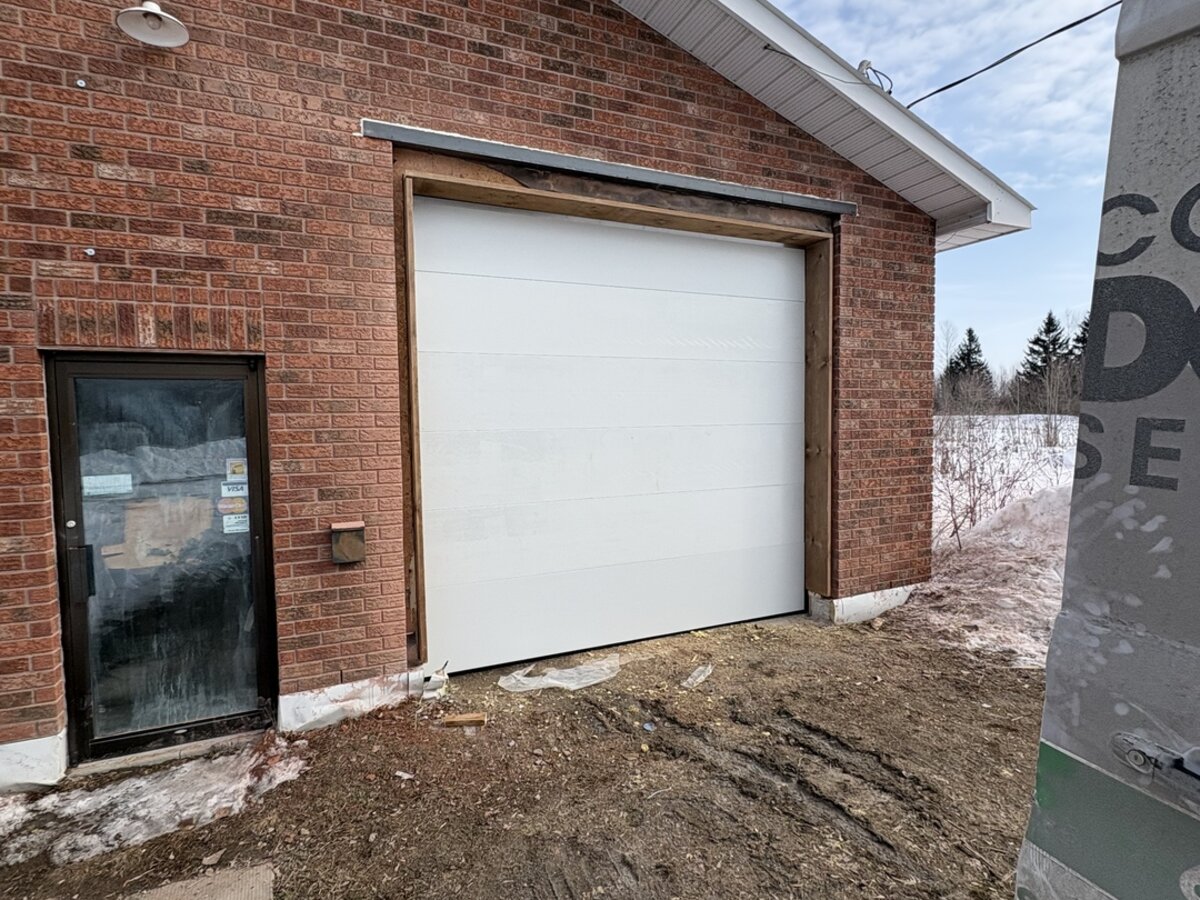 White single garage door on a red brick detached garage