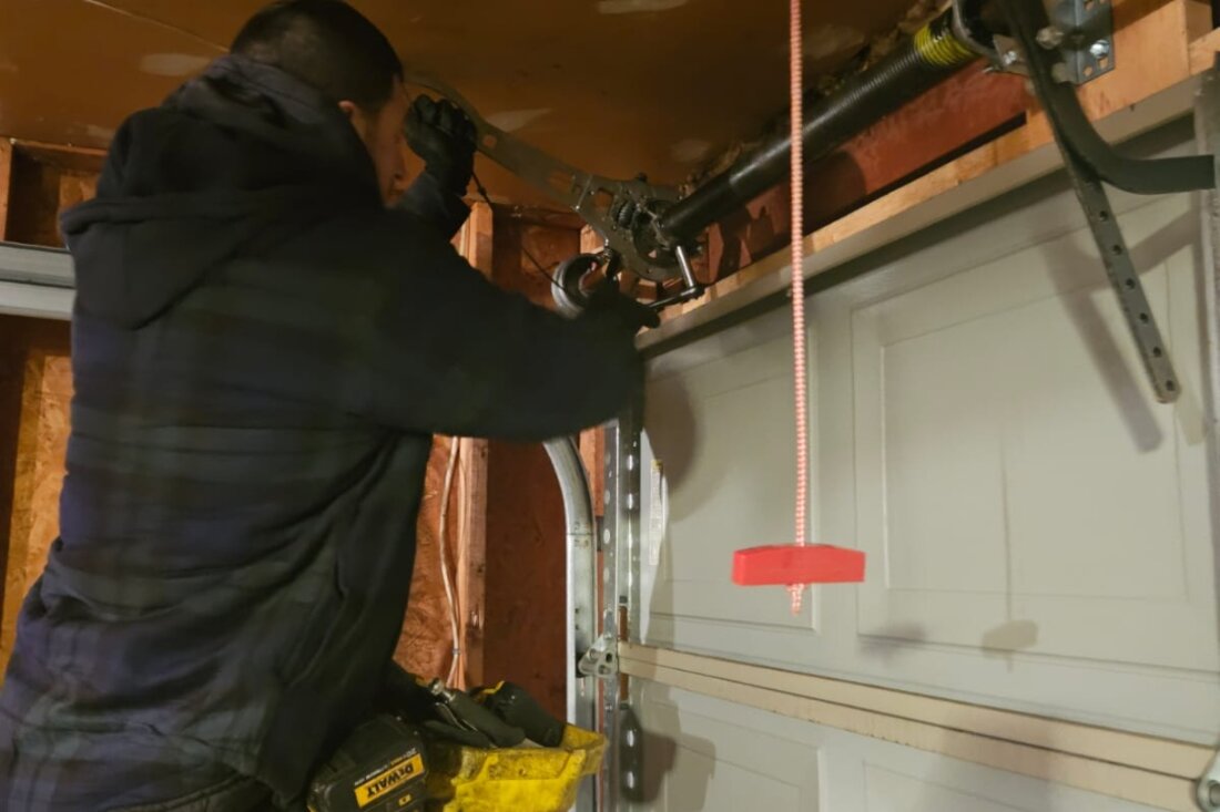 DPS Garage Doors technician performing a garage door maintenance tune-up on the spring and hardware in Ottawa
